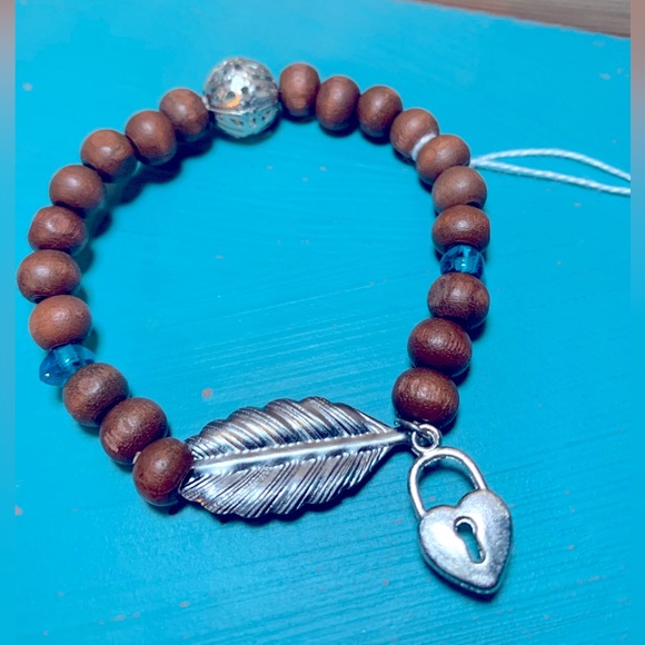Wood bead bracelet with feather and heart lock. Stretchy one size boho vibe. - Picture 1 of 7
